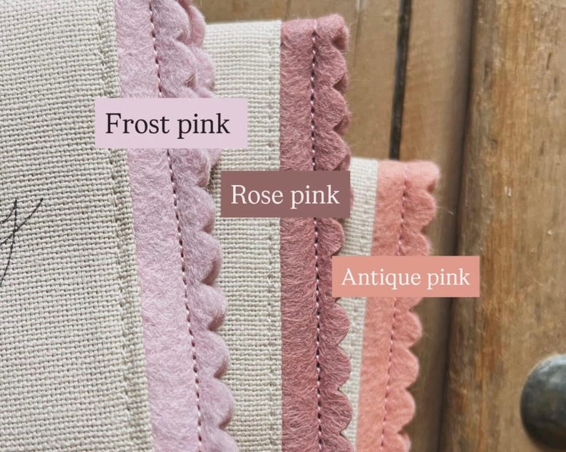 May include: Close-up of three fabric samples with scalloped edges in frost pink, rose pink, and antique pink. The samples are sewn onto a beige fabric. Text labels identify each color.