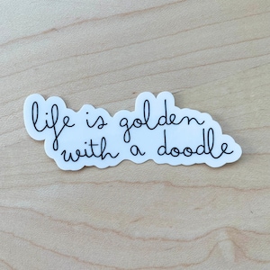 May include: White sticker with black cursive text that reads "life is golden with a doodle".