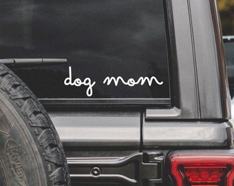 May include: A black car with a white vinyl decal on the back window that says "dog mom".