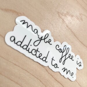 May include: White sticker with black cursive text that reads "maybe coffee is addicted to me".