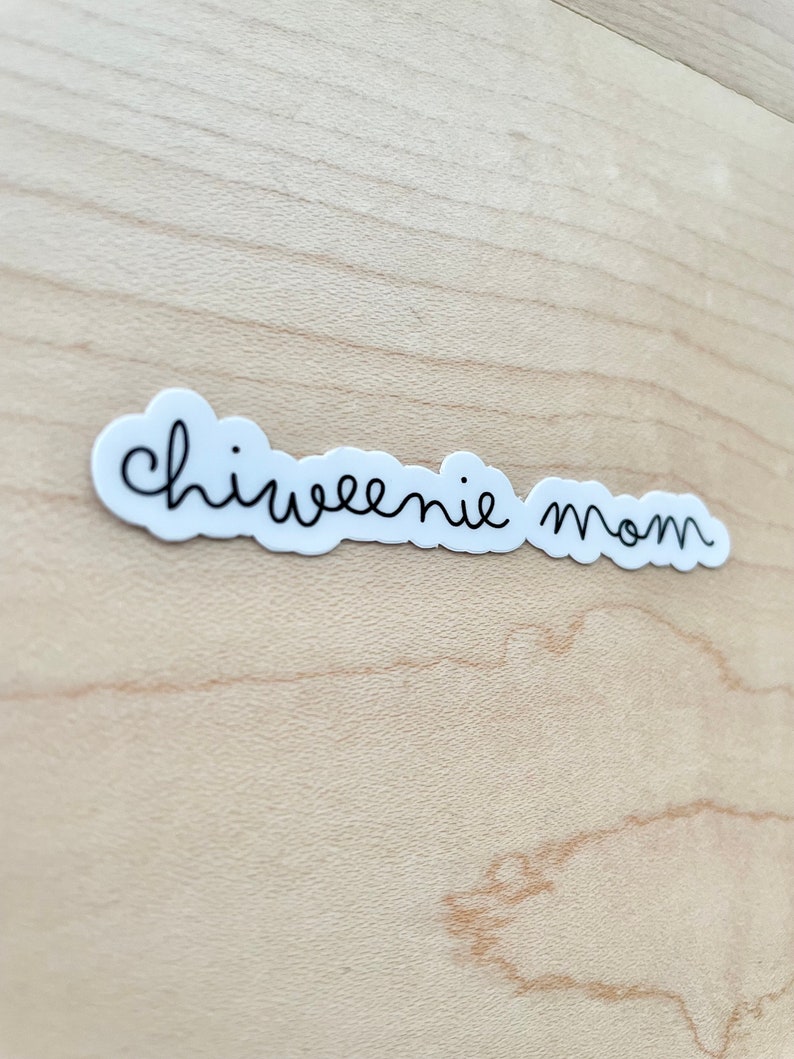 May include: White sticker with black cursive text that reads "chiweenie mom" on a light wood background.