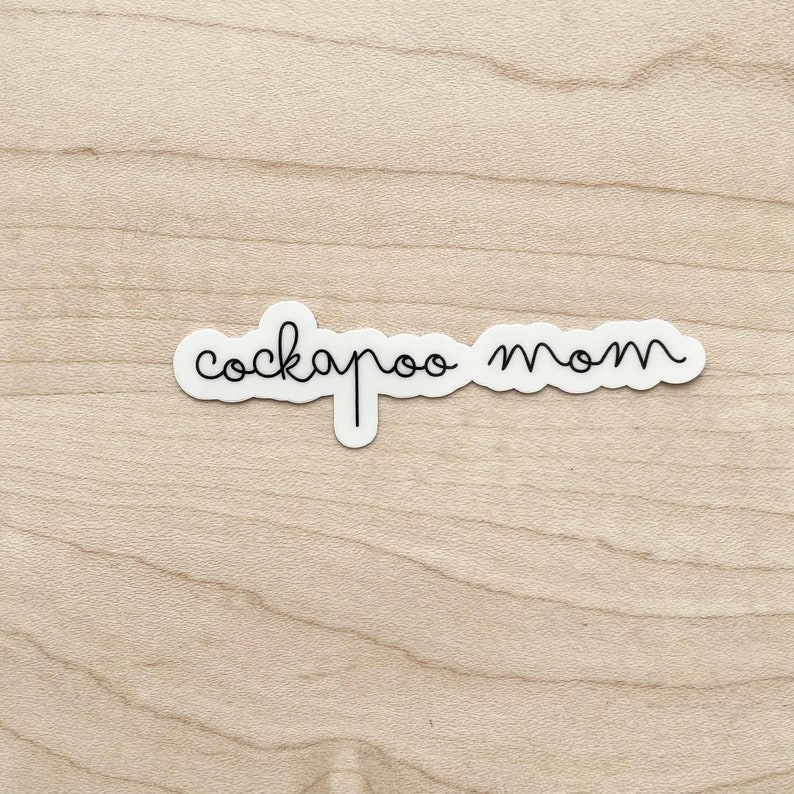 May include: White sticker with black cursive text that reads "cockapoo mom".