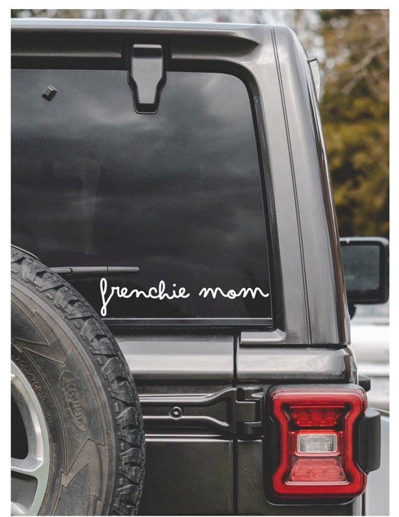 Puede incluir: Un coche negro con una calcoman&iacute;a de vinilo blanco en la ventana trasera que dice "frenchie mom".