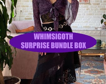 Puede incluir: Una blusa morada de manga larga con lazo y mangas acampanadas, combinada con una falda negra. La imagen presenta el texto "WHIMSIGOTH SURPRISE BUNDLE BOX" en un óvalo morado. El conjunto tiene una estética gótica.