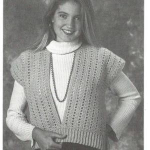 Może przedstawiać: Jasny beżowy kamizelka z szydełka z głębokim dekoltem w kształcie litery V, noszona na białym golfie. Kamizelka ma teksturowany, ażurowy wzór i krótkie rękawy. Widoczny jest naszyjnik z koralików. Obraz jest czarno-biały.