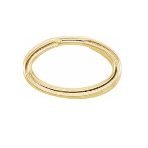 May include: A gold-colored oval jump ring, a metal ring with a gap, used for attaching jewelry components.