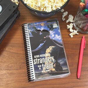 EXTRAÑOS EN UN TREN Cuaderno VHS reciclado