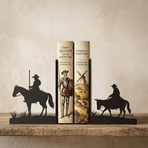 Puede incluir: Dos sujetalibros de metal negro con siluetas de un jinete a caballo y un jinete en burro, sosteniendo dos libros titulados Don Quijote de la Mancha y Novelas Ejemplares de Miguel de Cervantes, con una ilustraci&oacute;n de un molino.