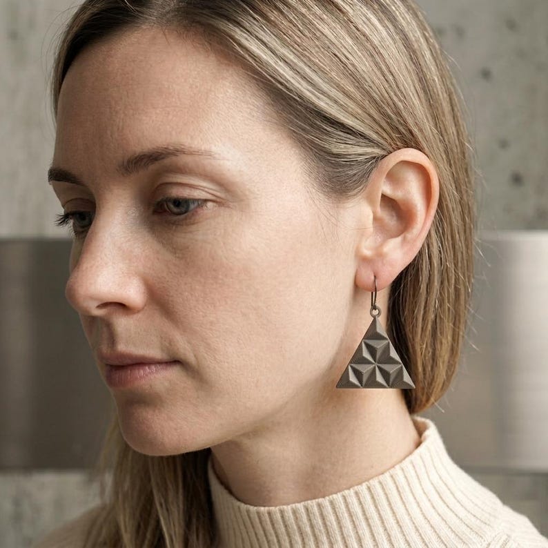 May include: A set of three ceramic mugs with a speckled, matte finish. The mugs are in shades of cream, light brown, and dark brown. Each mug has a simple, minimalist design, perfect for coffee or tea.