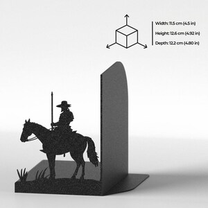 Puede incluir: Un sujetalibros de metal negro con la silueta de una persona a caballo sosteniendo una lanza. Las dimensiones del producto son 11,5 cm de ancho, 12,6 cm de alto y 12,2 cm de profundidad, junto con un diagrama de un cubo en 3D.