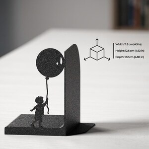 May include: A black metal bookend featuring a silhouette of a child holding a balloon. The product dimensions are listed as 4.5 inches in width, 4.92 inches in height, and 4.80 inches in depth, accompanied by a small cube diagram with directional arrows.