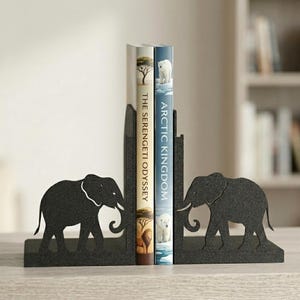 May include: Black metal elephant bookends with a cutout design. The bookends are holding two books with titles "The Serengeti Odyssey" and "Arctic Kingdom". The bookends are on a light-colored wooden surface.