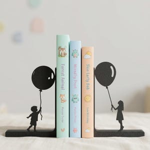 May include: A pair of black metal bookends featuring silhouettes of a child holding a balloon on each end. The bookends support three books with spines titled Forest Animal by Marcus Carter, Miendliy Treat by Marcus Pfister, and Skin Larty Bob by Sam Mcbratney.