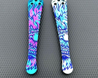 May include: Two decorative metal pieces featuring a vibrant flame design in blue, turquoise, and pink. Each piece has three holes at the top and a rounded bottom. The background is a textured, dark grey surface.