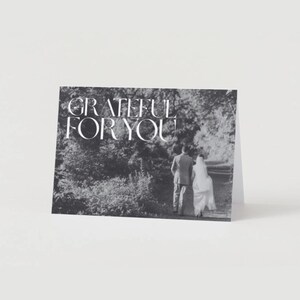 May include: Black and white photo of a couple walking away from the camera in a wooded area. The text "GRATEFUL FOR YOU" is printed in white on the image.