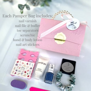 May include: A pink mini pamper set includes nail varnish, nail file, toe separators, scrunchie, hand & body lotion, and nail art stickers. The set is packaged in a pink embossed box with a ribbon handle and a tag that reads "Mini pamper set".