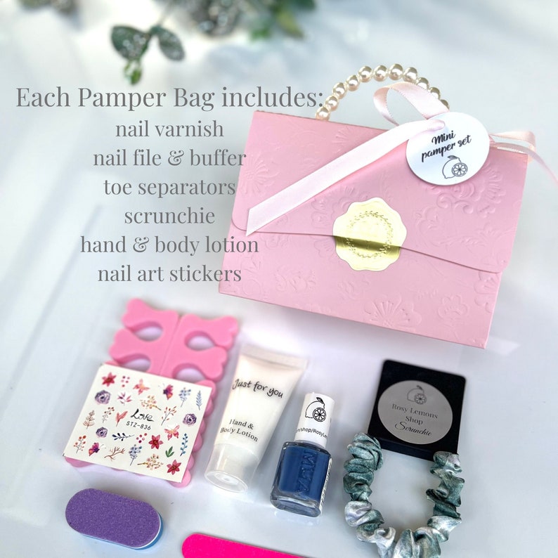 May include: A pink mini pamper set includes nail varnish, nail file, toe separators, scrunchie, hand & body lotion, and nail art stickers. The set is packaged in a pink embossed box with a ribbon handle and a tag that reads "Mini pamper set".