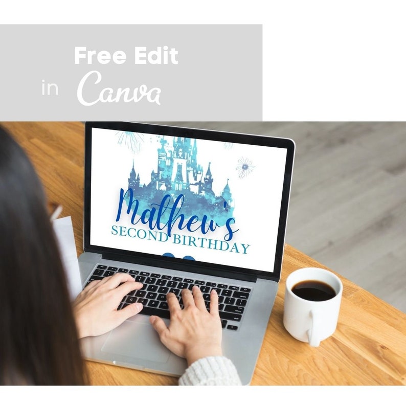 May include: A laptop screen displaying a blue and white watercolor illustration of a castle with the text "Mathew's Second Birthday" on a white background. The laptop is on a wooden table with a cup of coffee.