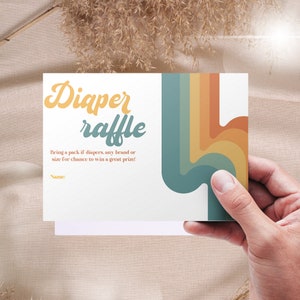 Puede incluir: Una tarjeta blanca con un dise&ntilde;o de arco&iacute;ris colorido y el texto "Diaper raffle" en una fuente retro. El texto debajo dice "Bring a pack of diapers, any brand or size for a chance to win a great prize!" y "Name:"