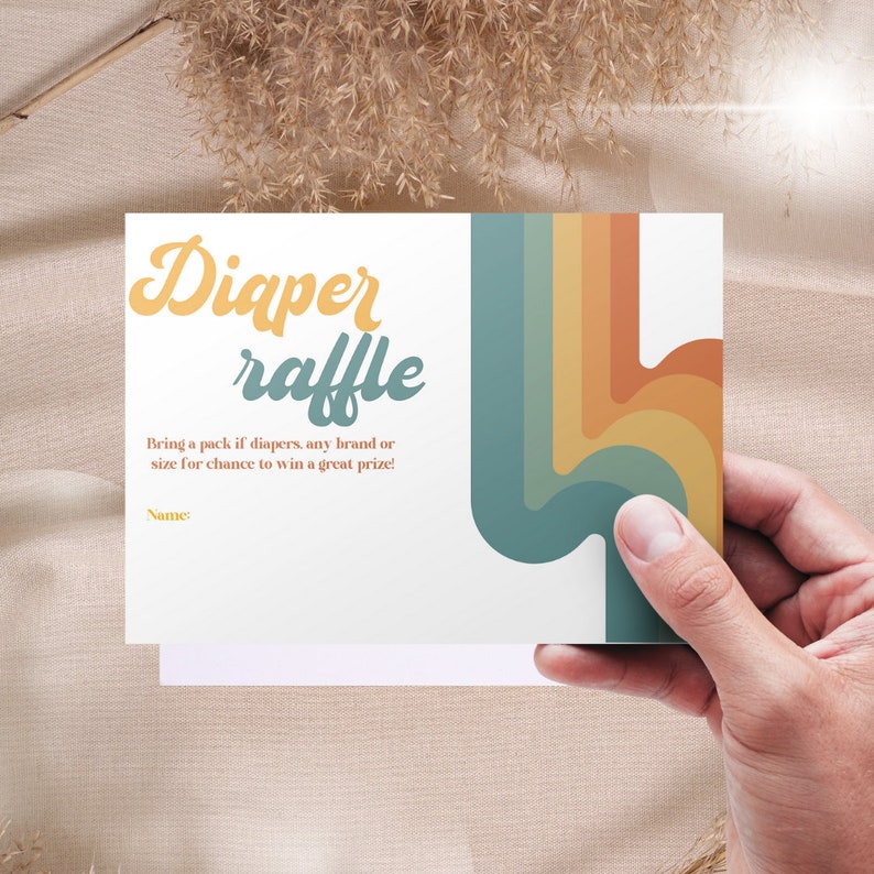 Puede incluir: Una tarjeta blanca con un dise&ntilde;o de arco&iacute;ris colorido y el texto "Diaper raffle" en una fuente retro. El texto debajo dice "Bring a pack of diapers, any brand or size for a chance to win a great prize!" y "Name:"