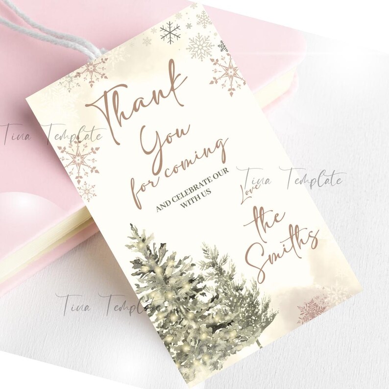 May include: A white thank you card with a winter theme. The card features two stylized trees with white lights and snowflakes. The text on the card reads "Thank you for coming and celebrate our with us, love the Smiths".