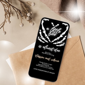 May include: A black and white digital invitation for a baby shower. The invitation features a skeleton hand heart with the text "a little boo is almost due". The invitation also includes the names "Carson and Annie" and details for the event.