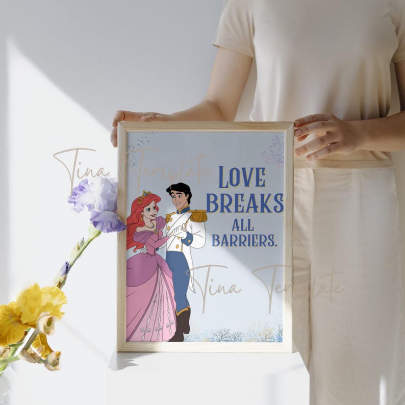 Op de afbeelding: Een blauwe en witte printbare wandkunstprint met Ariel en Prins Eric uit Disney's The Little Mermaid. De print heeft de tekst "Love Breaks All Barriers."