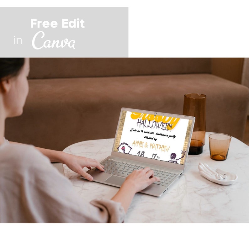 May include: A person using a silver laptop displaying a Halloween party invitation. The invitation features the word "HALLOWEEN" in yellow, along with event details and the text "Free Edit in Canva."