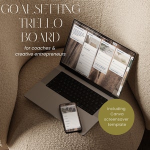 Op de afbeelding: Een laptopcomputer die een Trello-bord weergeeft met de tekst "Goal Setting Trello Board for coaches & creative entrepreneurs". De laptop staat op een beige fauteuil. Een smartphone met een vergelijkbaar Trello-bord ligt op de armleuning van de fauteuil. De tekst "Including Canva screensaver template" wordt weergegeven in een cirkel aan de rechterkant van de afbeelding.