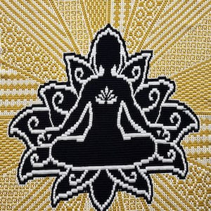 May include: A black and white crochet design of a person sitting in a lotus position with a flower in their chest. The design is surrounded by a yellow and white geometric pattern.