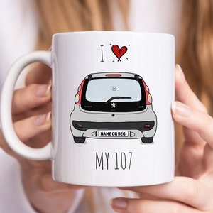 May include: White ceramic mug with a red heart and the text "I ♥ My 107". A cartoon illustration of a grey Peugeot 107 car is on the mug.