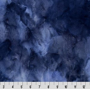 May include: A blue fabric with a marbled, swirled pattern. The fabric has a soft, fuzzy texture.