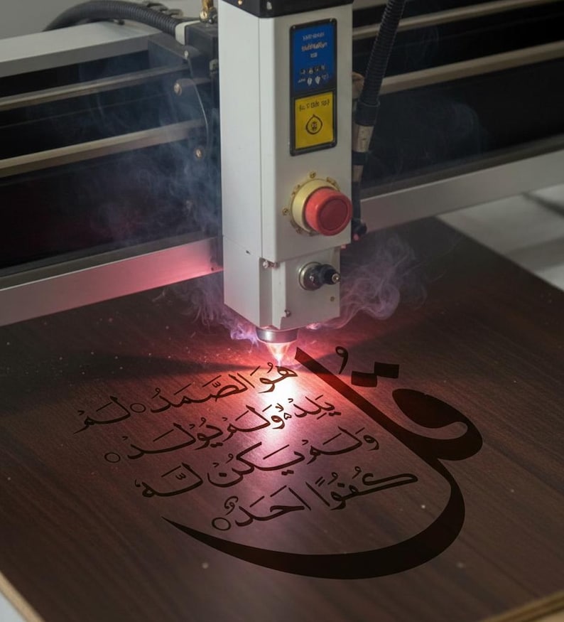 K&ouml;nnte beinhalten: Eine Lasergravurmaschine graviert arabische Kalligraphie auf eine Holzoberfl&auml;che. Der Laser emittiert einen roten Strahl, der Rauch erzeugt, w&auml;hrend er die komplizierte Schrift graviert. Das Holz hat einen warmen, braunen Farbton, und der Text ist dunkel.