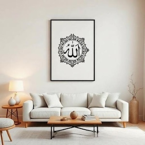 K&ouml;nnte beinhalten: Ein gerahmter Schwarz-Wei&szlig;-Kunstdruck mit arabischer Kalligraphie. Das Kunstwerk zeigt das Wort "Allah" in einem dekorativen kreisf&ouml;rmigen Design. Der Druck h&auml;ngt &uuml;ber einem wei&szlig;en Sofa in einem Wohnzimmer.