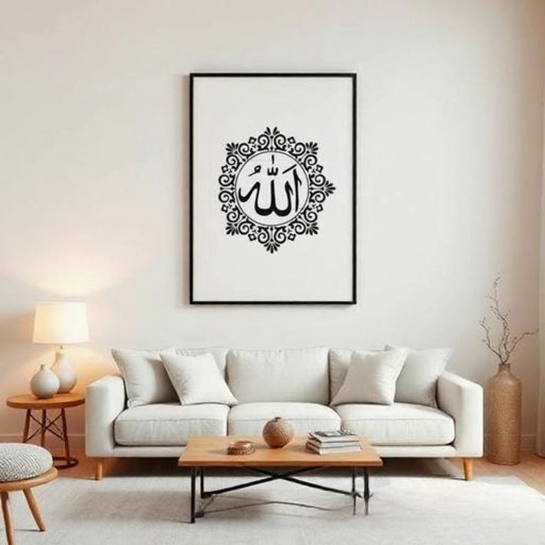 K&ouml;nnte beinhalten: Ein gerahmter Schwarz-Wei&szlig;-Kunstdruck mit arabischer Kalligraphie. Das Kunstwerk zeigt das Wort "Allah" in einem dekorativen kreisf&ouml;rmigen Design. Der Druck h&auml;ngt &uuml;ber einem wei&szlig;en Sofa in einem Wohnzimmer.