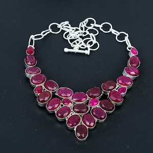 Peut inclure: Un collier en argent avec un design en cascade de pierres précieuses roses de forme ovale. Le collier a une chaîne simple et un fermoir à ressort.