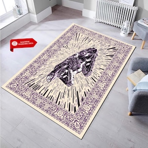 Puede incluir: Alfombra rectangular con fondo crema y diseño de nave espacial morada y negra. La alfombra tiene un borde decorativo y una explosión de líneas que emanan de la nave espacial. El texto "MACHINE WASHABLE RUG" está en la esquina superior izquierda.