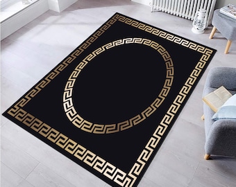 May include: Black area rug with a gold Greek key border and a large gold Greek key circle in the center.