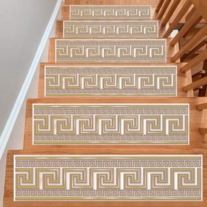 May include: Set of five non-slip stair treads with a beige background and a gold Greek key pattern. The treads are designed to add a decorative touch to stairs and provide extra traction.