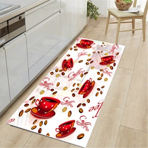 May include: White kitchen runner rug with a red coffee cup and coffee bean design. The rug has the word "Coffee" written on it multiple times.