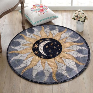 Puede incluir: Una alfombra redonda de mosaico gris y beige con un diseño de sol y luna. El sol está hecho de azulejos beige y la luna es negra con estrellas blancas.