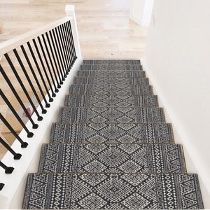 May include: A set of black and white patterned stair treads with a beige border. The treads are made of a soft, durable material and are designed to protect your stairs from wear and tear.