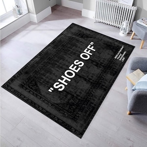 May include: Black and white rug with a distressed look and a white border. The text "SHOES OFF" is printed in white in the center of the rug.