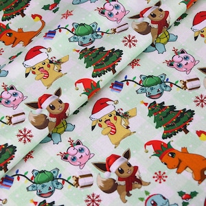 Könnte beinhalten: Stoff mit einem sich wiederholenden Muster von Zeichentrickfiguren mit Weihnachtsmützen und Weihnachtsbäumen auf hellgrünem Hintergrund. Zu den Figuren gehören Pikachu, Evoli, Bisasam, Glumanda und Pummeluff. Der Stoff zeigt auch Schneeflocken und Geschenkboxen.