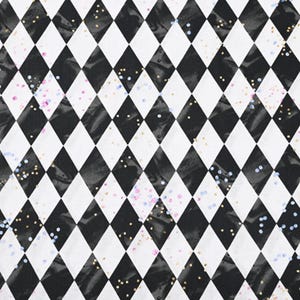 May include: A black and white harlequin pattern with a diamond design. The diamonds are interspersed with small flecks of gold, pink, and blue glitter. The pattern is a repeating design.