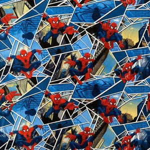 Könnte beinhalten: Ein blauer und gelber Stoff mit einem sich wiederholenden Muster von Spiderman, der durch eine Stadtkulisse schwingt. Der Stoff besteht aus einer Reihe von geometrischen Formen.