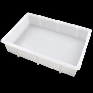 May include: A white rectangular plastic tray with a raised edge and a flat base. The tray has vertical supports on the sides and is designed for general use. The tray is made of a smooth, opaque material.