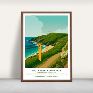 May include: A framed print depicting the South West Coast Path, showcasing a coastal scene with a path, sea, and sky. The print includes the text "South West Coast Path," "Sarah and John - August 2022," and distance and elevation details.