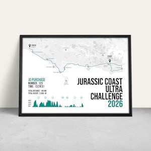 May include: A framed print of the Jurassic Coast Ultra Challenge 2026. The teal route map shows the course with start and finish points. Text includes "Jo Purchase", "Number: 123", and "Total Distance: 100 km". The frame is black.