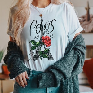 May include: White t-shirt with a black and white illustration of the Eiffel Tower and a red rose. The text "Paris" is written in cursive above the tower.